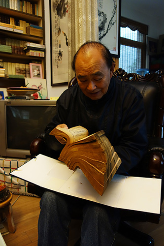 川派琴人唐中六先生正在翻阅自己收藏的《自远堂琴谱》